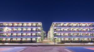 two tall buildings with lights on them at night at Runway 1331 -ENLIGHT Youth Hostel in Hong Kong