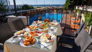 a table with plates of food on a balcony at Buyuk Berk Hotel in Ayvalık