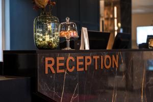 a reception sign with two glasses and a vase at Hotelli Sodankylä in Sodankylä