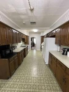 a large kitchen with wooden cabinets and a tile floor at Big Comfy Home with King & Queen Beds in Lafayette