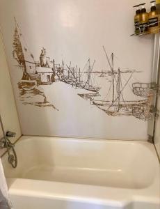 a bath tub with a drawing of a boat on the wall at Big Comfy Home with King & Queen Beds in Lafayette +19 photos