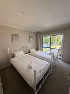 two beds in a bedroom with a large window at Millwater Retreat in Silverdale