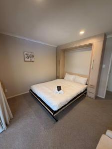 a bedroom with a bed with a book on it at Millwater Retreat in Silverdale +16 photos