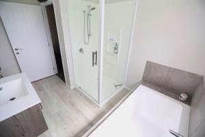 een badkamer met douche en wastafel bij Forest Charm by the Beach in Waitarere +2 foto's