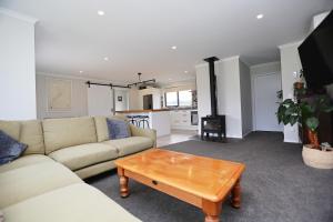 een woonkamer met een bank en een salontafel bij Forest Charm by the Beach in Waitarere