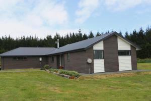 een huis met een grote tuin ervoor bij Forest Charm by the Beach in Waitarere