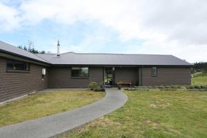 een huis met een loopbrug ervoor bij Forest Charm by the Beach in Waitarere
