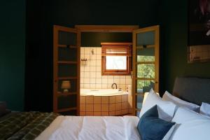 a bedroom with a bed and a bathroom with a sink at Central studio with spabath in Daylesford