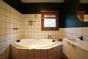 a bathroom with a tub and a sink at Central studio with spabath in Daylesford