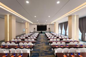 a large room with desks and chairs in front of a screen at HARRIS Hotel & Suites Nagoya Batam in Nagoya