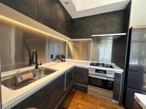 a kitchen with a sink and a stove at Duna Colorada Niseko in Rankoshi