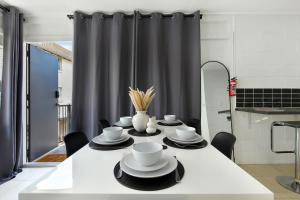a table with plates and cups on it in a kitchen at The Coastal Escape - Games & Vibes in Gold Coast