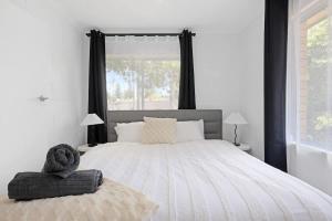 a bedroom with a large bed with a large window at The Coastal Escape - Games & Vibes in Gold Coast