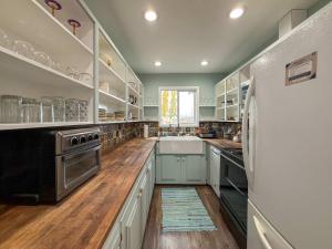 a large kitchen with white cabinets and a refrigerator at The Garden Gate in R Corner