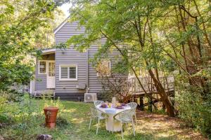 ein Tisch und Stühle vor einem kleinen Haus in der Unterkunft Cosy 2 Bedroom Cottage with spabath and fireplace in Mount Dandenong