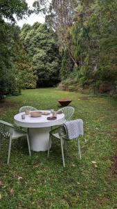 einen Tisch und Stühle im Gras in der Unterkunft Cosy 2 Bedroom Cottage with spabath and fireplace in Mount Dandenong