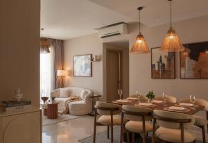 ein Wohnzimmer mit Esstisch und Stühlen in der Unterkunft Rivergate Residence by Maison de Gu - Premium Studios, 2BRs, 3BRs Living in District 4, Steps from District 1, 300M BUI VIEN in Ho-Chi-Minh-Stadt