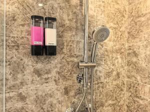 a shower with a blow dryer and a shower head at R&F Princess Cove 2BR Sea View JB CIQ Spacious in Johor Bahru +12 photos