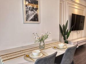 a dining room with a table with chairs and a tv at R&F Princess Cove Studio Sea Front CIQ-Singapore in Johor Bahru