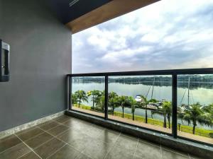 a balcony with a view of the water and palm trees at R&F Princess Cove Studio Sea Front CIQ-Singapore in Johor Bahru