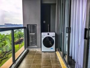 a washing machine on a balcony with a view at R&F Princess Cove Studio Sea Front CIQ-Singapore in Johor Bahru