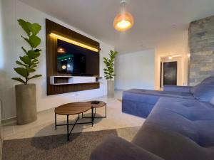 a living room with a blue couch and a tv at Apartamento moderno en cabecera Bucaramanga in Bucaramanga