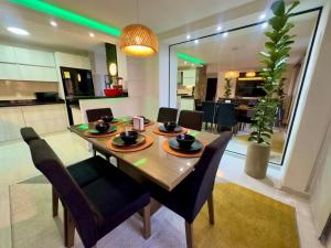 a dining room with a table and chairs and a kitchen at Apartamento moderno en cabecera Bucaramanga in Bucaramanga