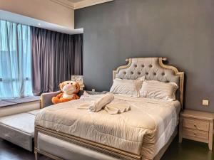 a bedroom with a bed with a teddy bear next to a window at R&F Princess Cove 3BR CozyDesign JB Central CIQ in Johor Bahru