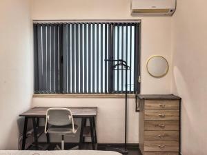 a bedroom with a desk and a chair and a window at R&F Princess Cove 3BR CozyDesign JB Central CIQ in Johor Bahru +12 photos