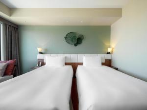 a room with two beds and a couch at Hyatt Regency Naha, Okinawa in Naha