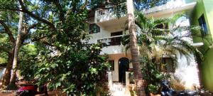 a building with a palm tree in front of it at Jacinta's - By the beach - Cruz's place in Calangute