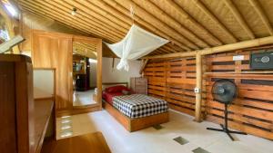 a bedroom with a bed in a wooden wall at Serenity Eco Guesthouse - CHSE certified in Canggu +123 photos