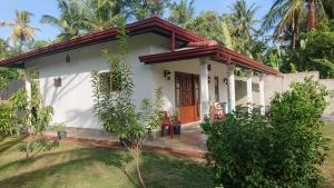 a small white house with a red roof at Paddy view villa near Bentota in Bentota