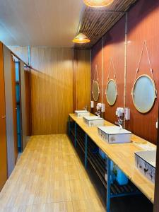 ein Bad mit 3 Waschbecken und 2 Spiegeln in der Unterkunft Tam Coc Mango hostel in Vũ Lâm