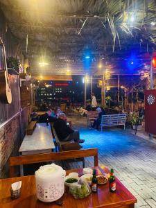 eine Gruppe von Personen, die in einem Zimmer mit einem Tisch sitzen in der Unterkunft Tam Coc Mango hostel in Vũ Lâm