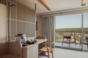 een kamer met een bureau en een balkon met stoelen bij Dayone Kilyos Hotel in Kilyos