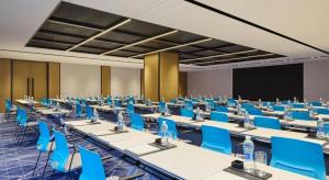 a room with tables and blue chairs and a screen at Four Points by Sheraton Kunshan in Kunshan
