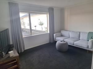 a living room with a couch and a window at The Mews - Country Stay in Rolleston