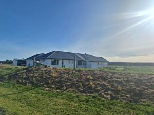a house with solar panels on top of a field at The Mews - Country Stay in Rolleston