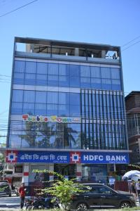 a large glass building with a hride bank sign on it at Hotel Rudra in Guwahati