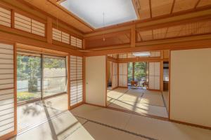 an empty room with wooden ceilings and windows at BANRYU 萬龍 バンリュウ in Iida