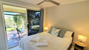 a bedroom with a bed and a sliding glass door at Hinterland Hideaway Farm Stay in Wolvi +38 photos