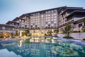 een hotel met een groot zwembad ervoor bij Wanda Jin Pingxiang in Pingxiang