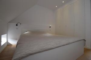 a white bedroom with a large bed in it at Stay in Ghent in Ghent