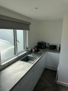 a kitchen with a sink and a window at Luxury Beachfront Lodge in Hest Bank