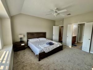 a bedroom with a bed and a ceiling fan at Katy Getaway - Relaxed 3BR Home with Serene Views in Hoffpauir Airport