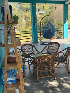 a group of chairs and a table on a porch at Vin's Villa & caffe in Bīr