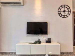 a white cabinet with a tv on a wall with a clock at R&F Princess Cove 2BR Sea View JB-SG CIQ Malls in Johor Bahru