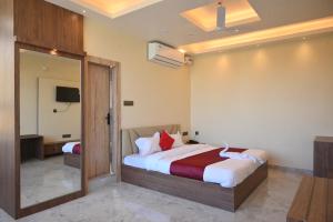 a hotel room with a bed and a mirror at Hotel Rudra in Guwahati