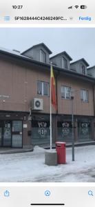 une photo d'un bâtiment avec un drapeau devant dans l'établissement Kirkenes town apartments, à Kirkenes